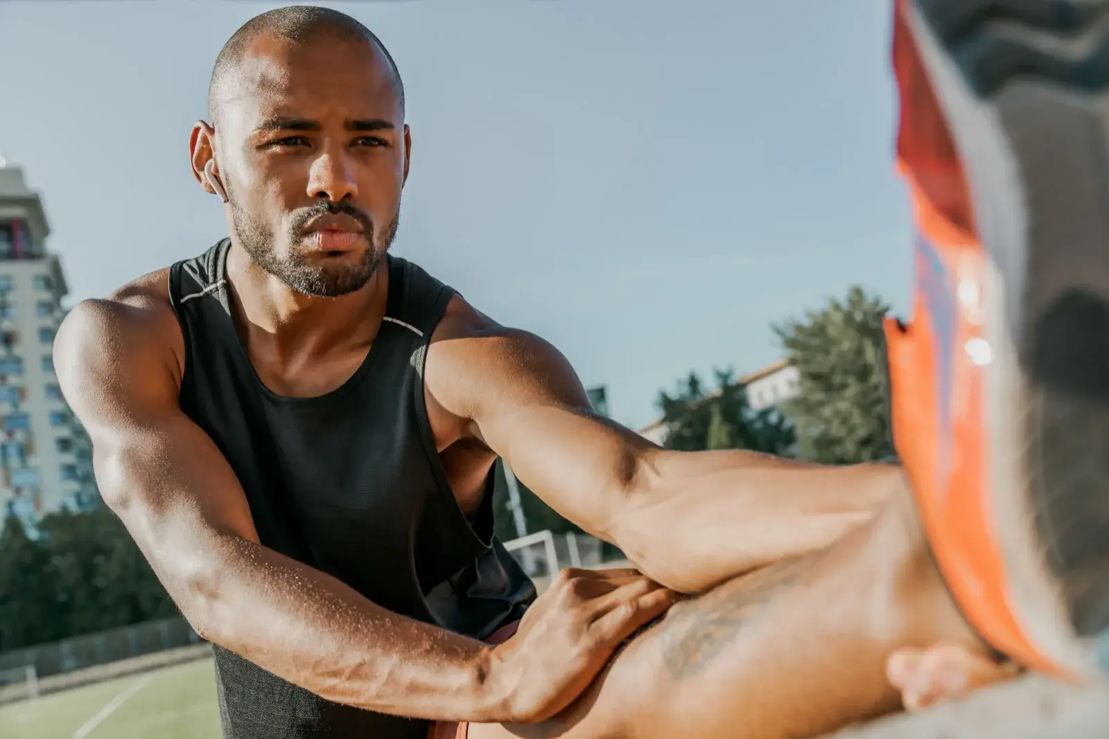 Athlete stretching his legs at a stadium during recovery