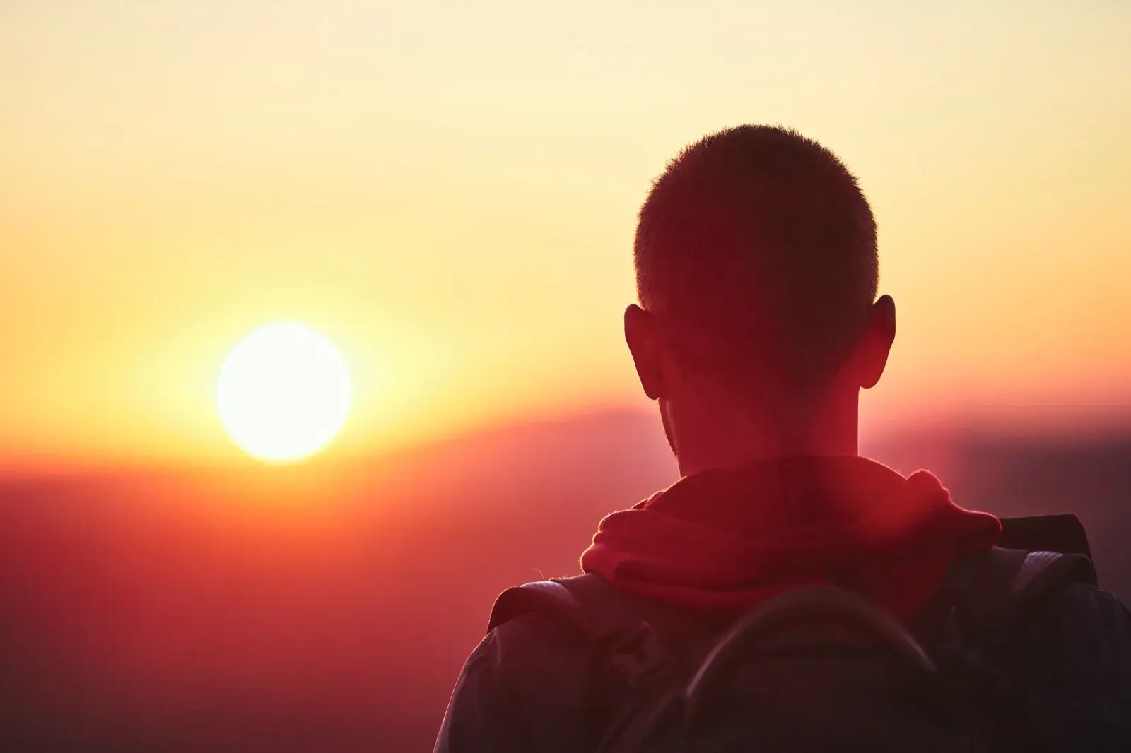 Man facing a mountain range at sunset, symbolizing a fresh start