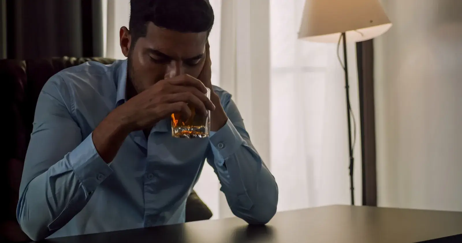 Man drinking alcohol alone to cope with stress