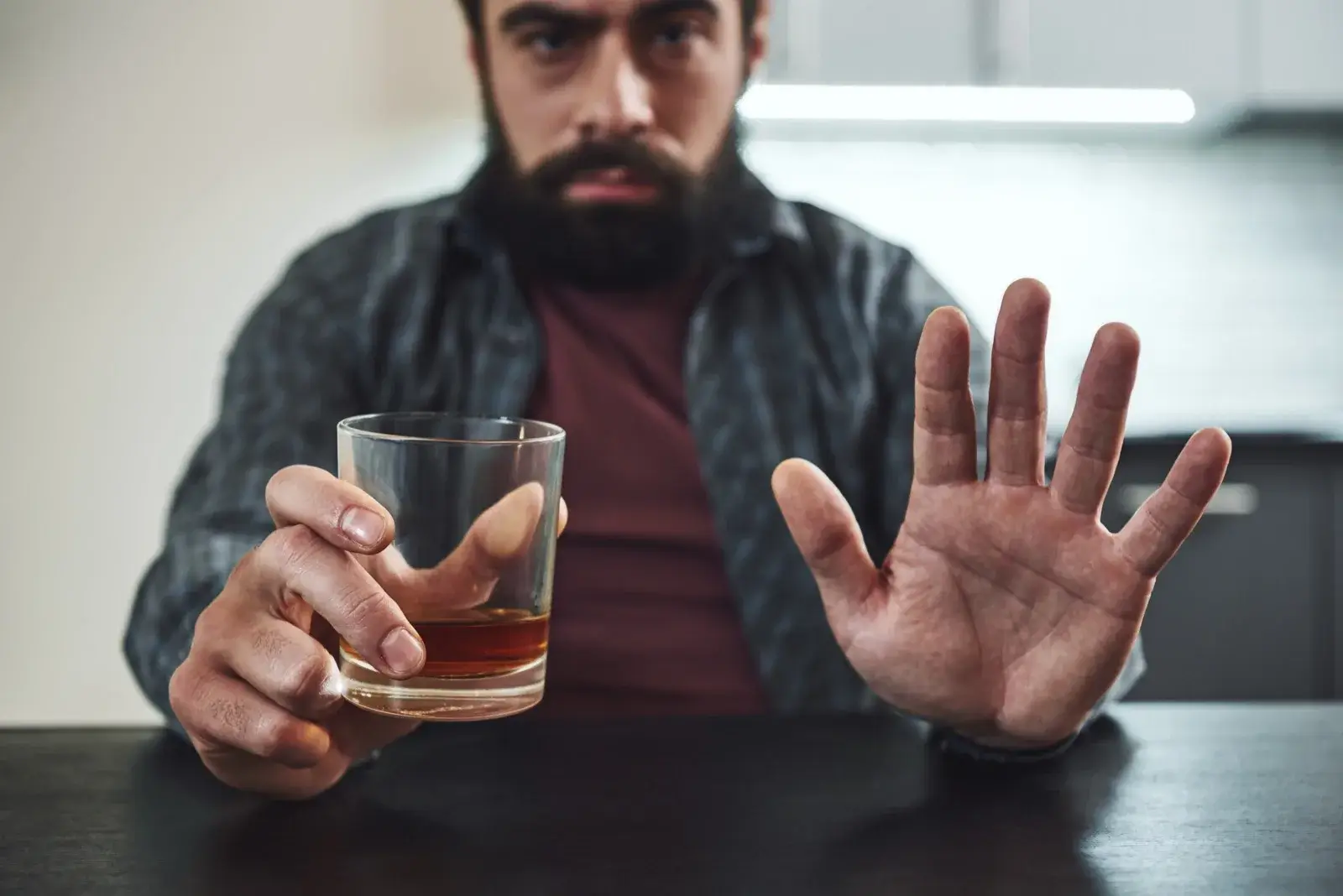 Man refusing a glass of alcohol, choosing sobriety