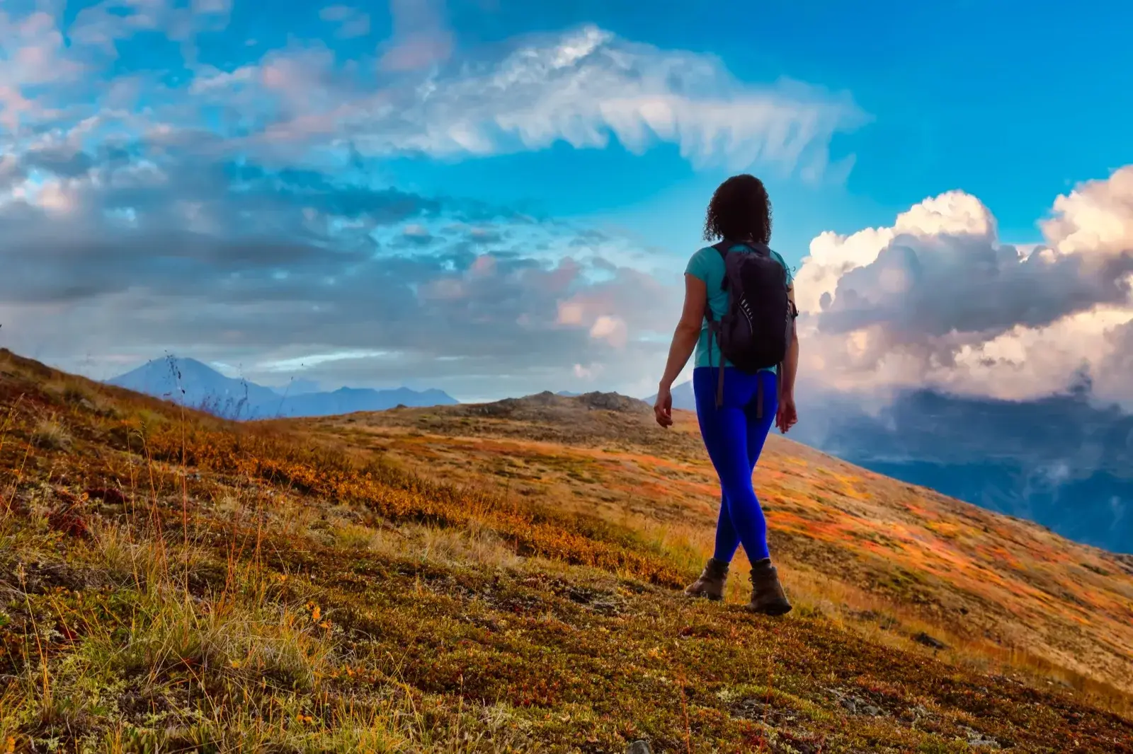 Woman hiking up a mountain trail, building resilience