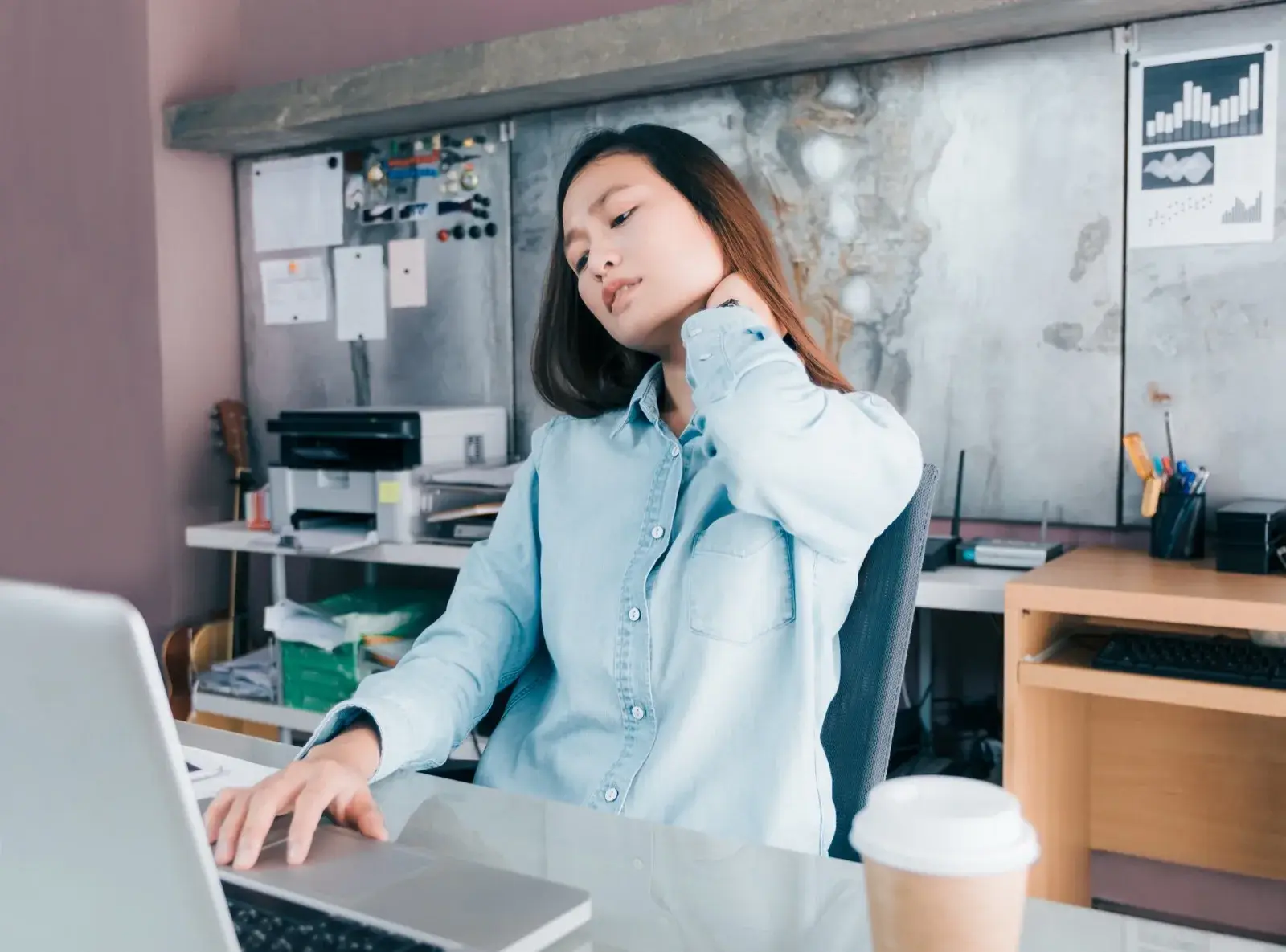 Woman with neck pain while working at her desk