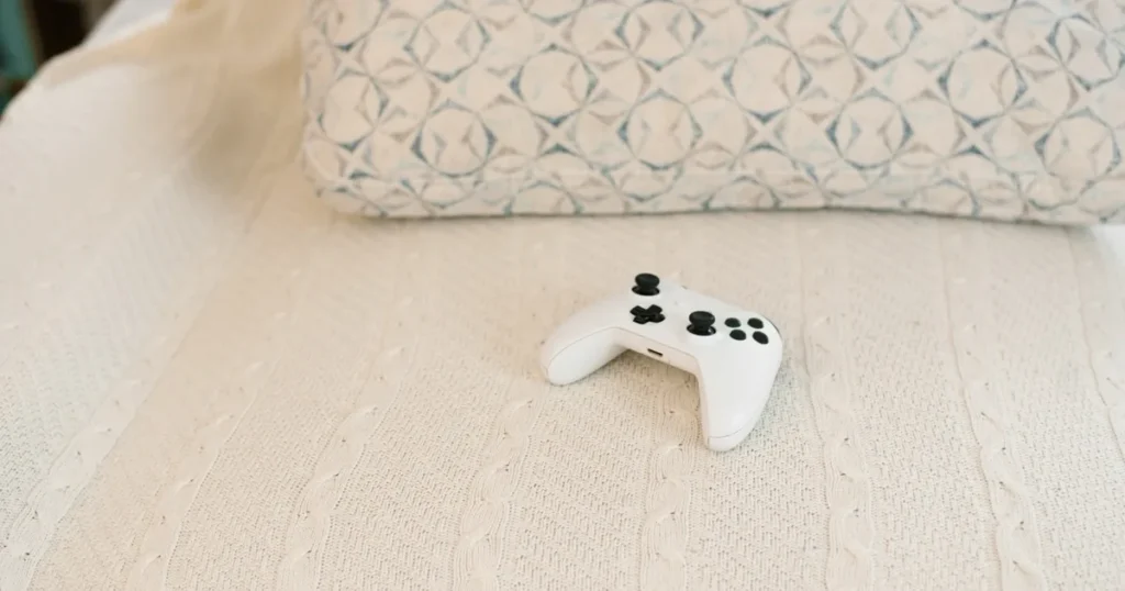 A game controller resting on a textured white blanket.