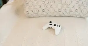 A game controller resting on a textured white blanket.