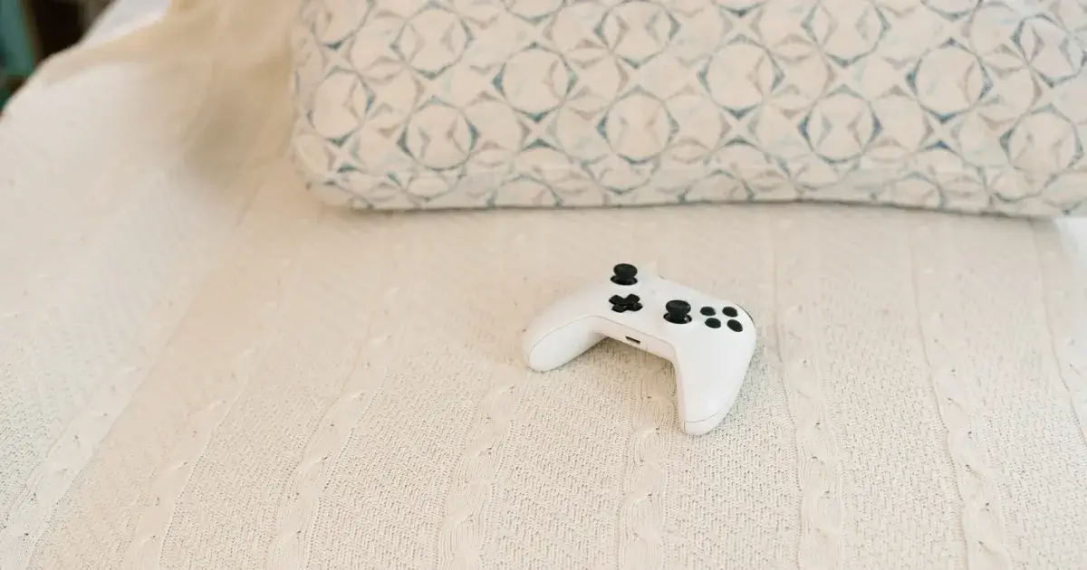 A game controller resting on a textured white blanket.
